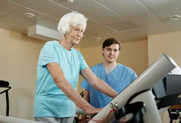 Patient walking on a treadmill with a therapist during the peripheral artery disease program