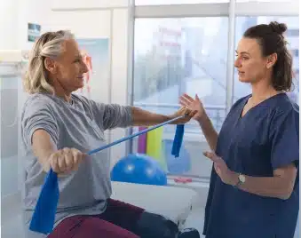 Therapist guiding a patient through a resistance band exercise