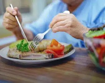 Patient eating a heart-healthy meal of fish and vegetables