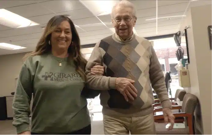 Girard Medical Center staff member walking arm in arm with an elderly patient
