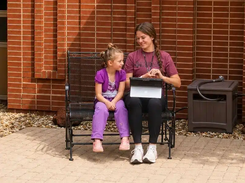 Speech therapist working one-on-one with a young patient at Girard Medical Center