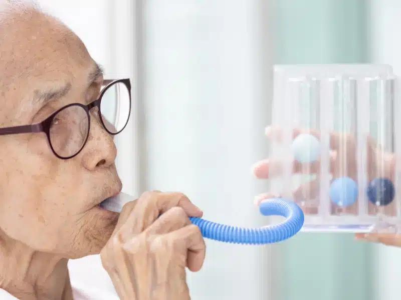 Patient using an incentive spirometer during respiratory therapy